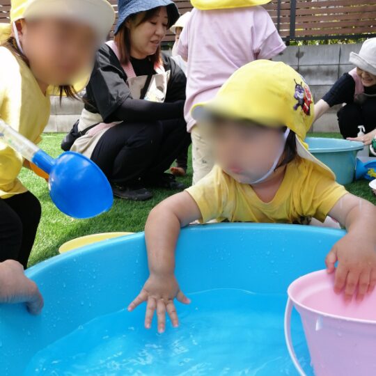 たらいを使って遊ぶ保育園児