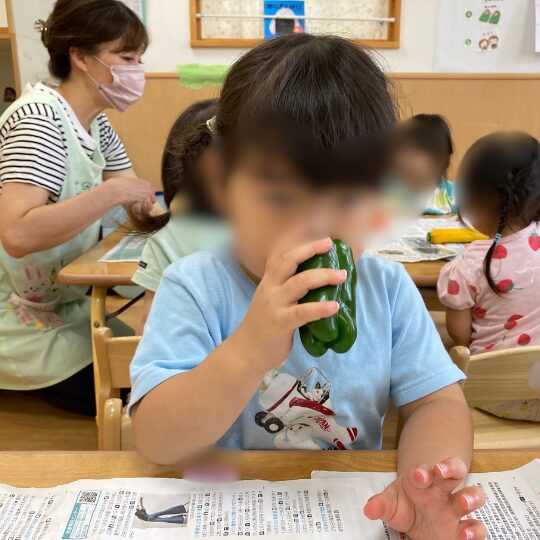 野菜を嗅ぐ保育園児