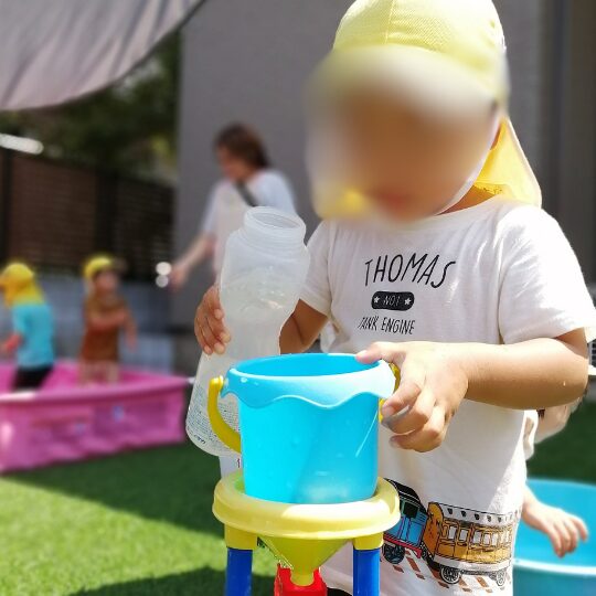 あっとホームママ・にじのこの小さなお庭で水遊びをする園児たち