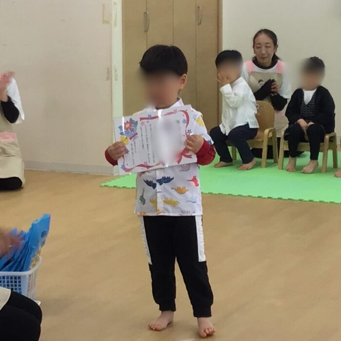卒園式 あっとほーむママ・にじのこ 卒園証書を見せる2歳児
