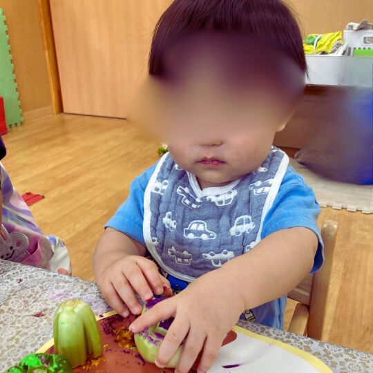 野菜スタンプを体験する0歳児