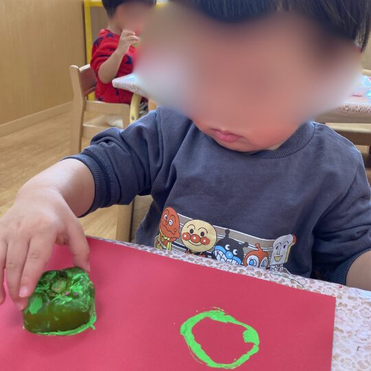 野菜スタンプを体験する1歳児