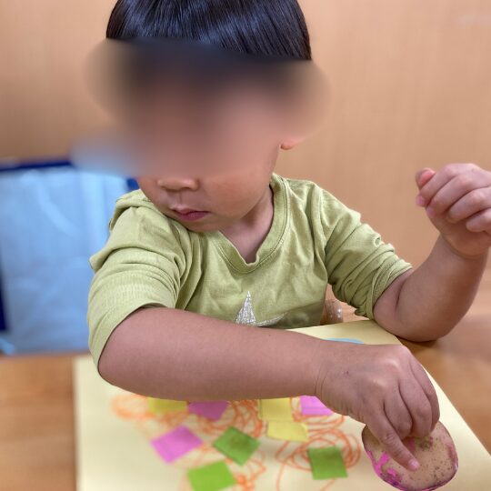 野菜スタンプを体験する2歳児