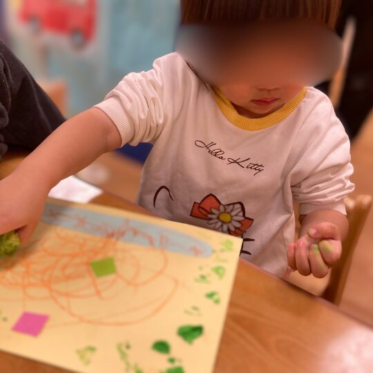 野菜スタンプを体験する2歳児