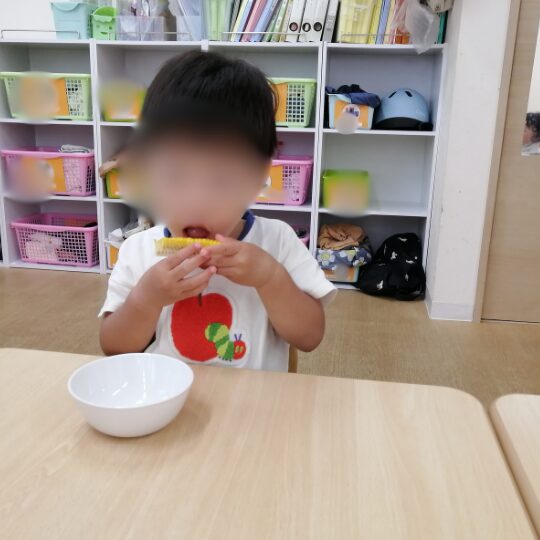 とうもろこしを食べる男児