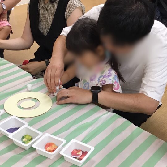 父親と制作をおこなう保育園児