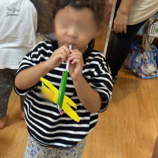 ストローを使った遊びをおこなう2歳児