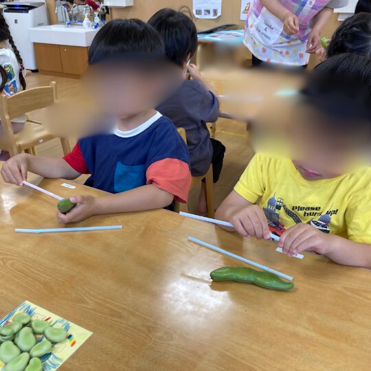 そらまめの鞘で工作をする保育園児