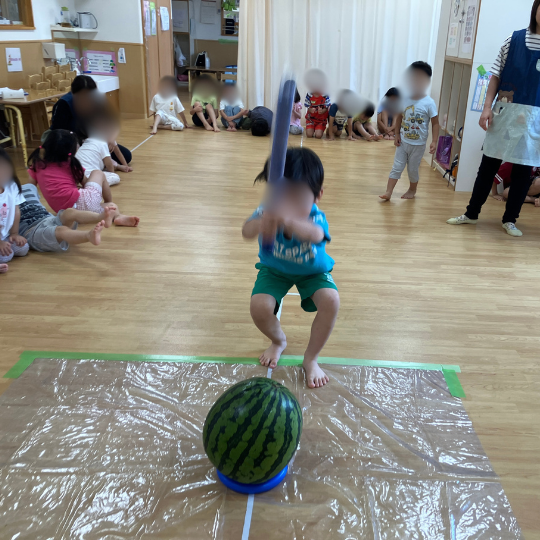 すいかわりをおこなう男児