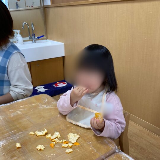 1歳児の1月食育活動(皮むきしたみかんを食べる)
